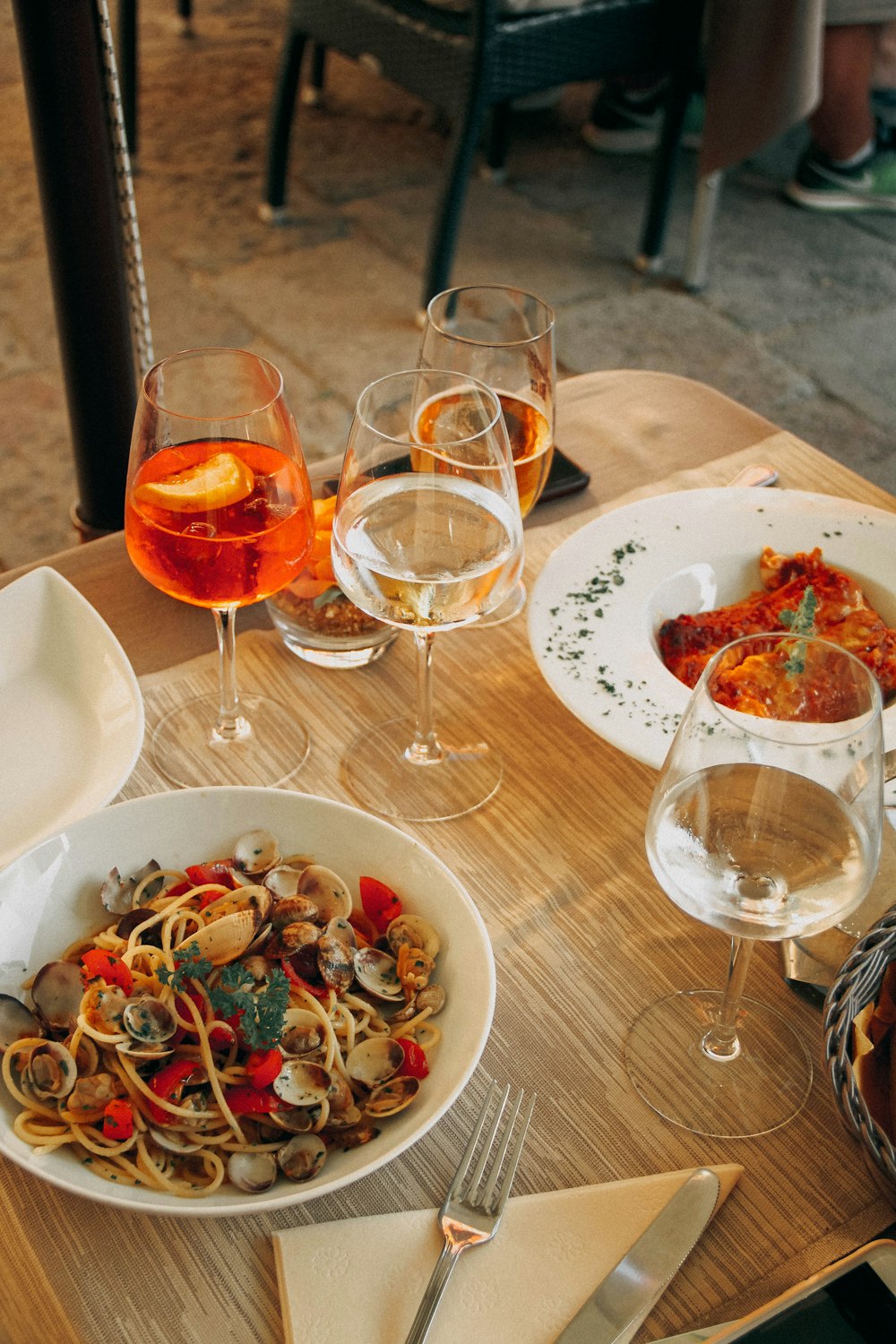 Cuatro copas de vino llenas y alimentos en la mesa