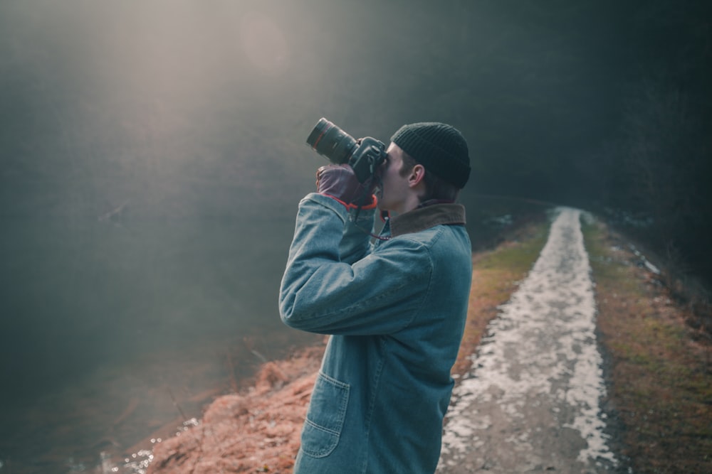 photo of man holding DLSR camera looking up and taking a photo