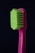 A close-up of a toothbrush with bright green bristles and a pink handle against a dark background.