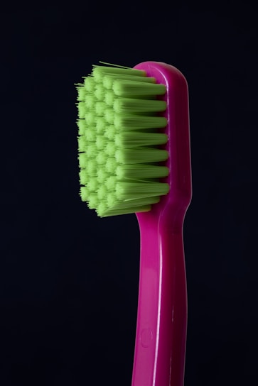 A close-up of a sleek, modern toothbrush resting on a bathroom counter.