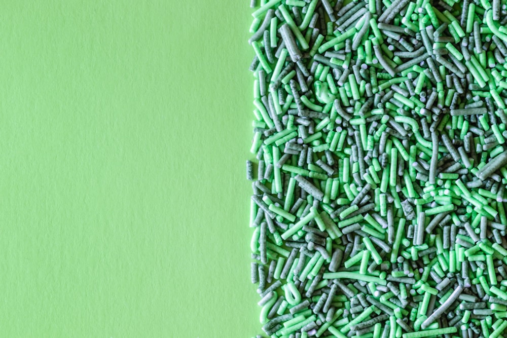 a pile of green sprinkles sitting on top of a green surface