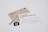 A white card with a handwritten message and printed text reads 'Unsplash wants to thank you.' The card is placed on a table with a brown envelope and Unsplash stickers. The message on the card expresses gratitude, and the envelope has an address label.