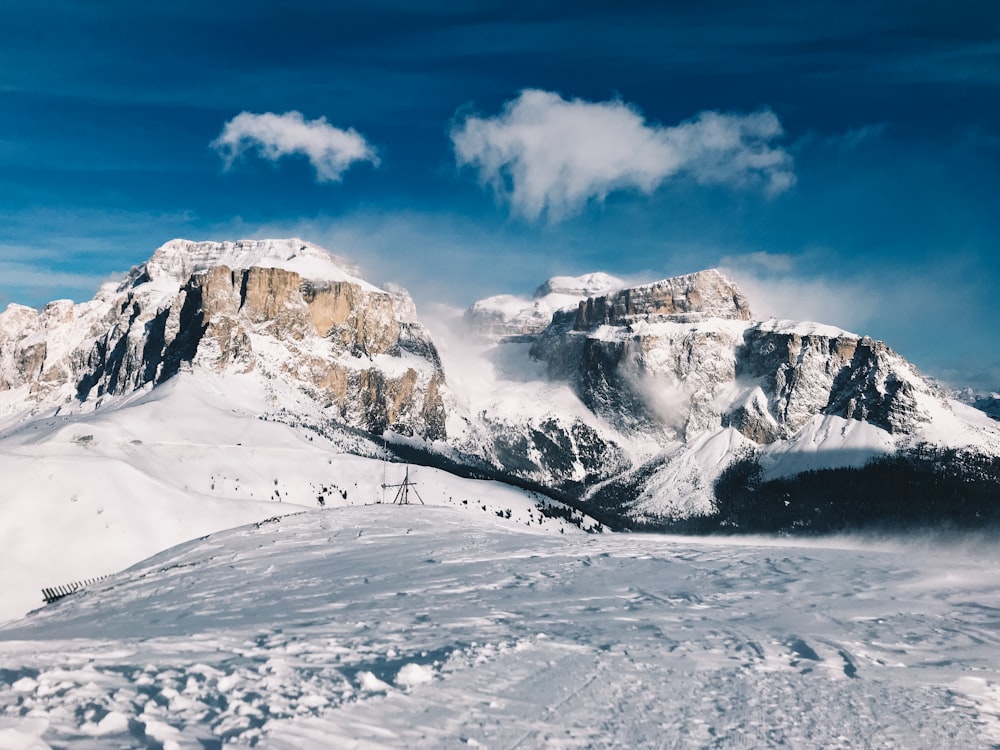 snow covered mountain under white clouds during daytime