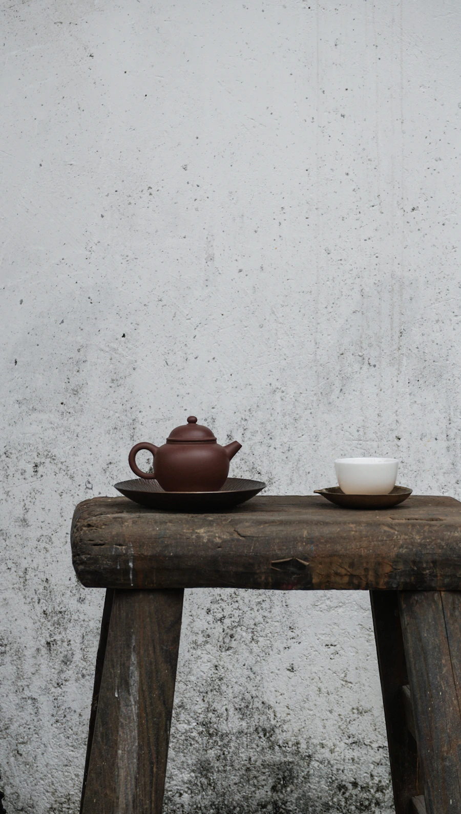 Detalle cálido — tetera y taza sobre mesa de madera