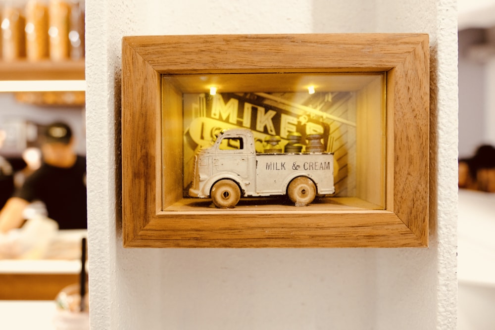 gray truck toy with brown wooden frame on wall