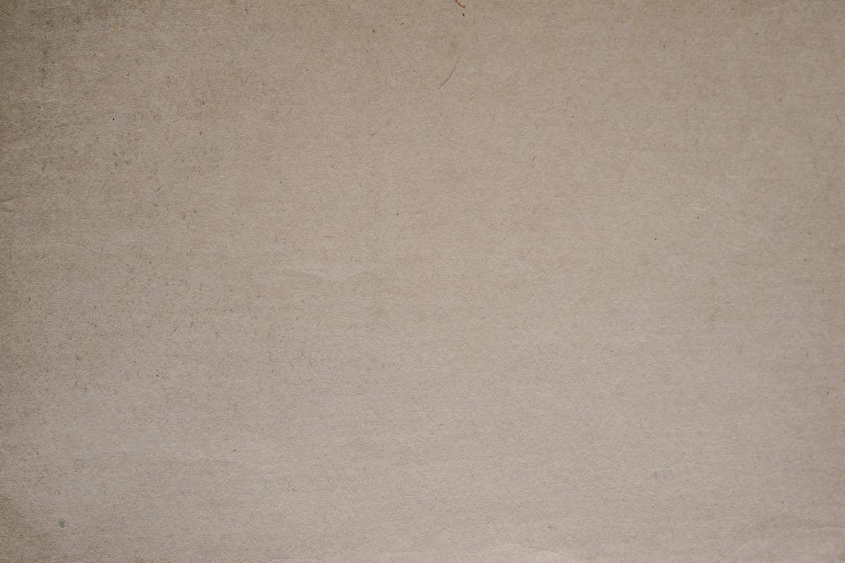 a brown paper background with a black and white cat sitting on top of it
