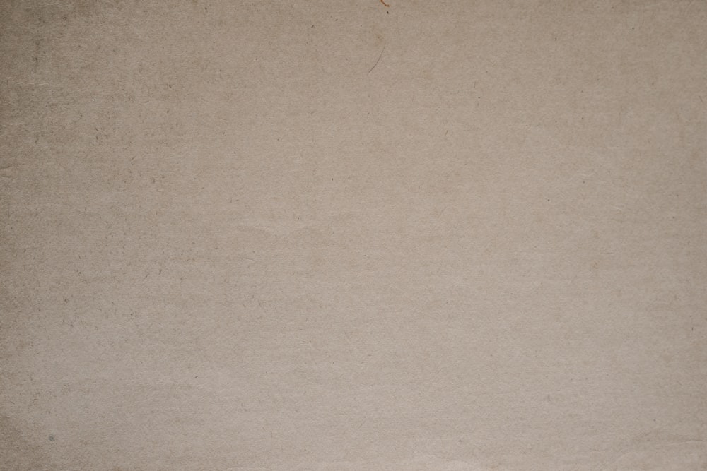 a brown paper background with a black and white cat sitting on top of it