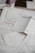 A collection of old papers and documents with printed text and maps laid out overlapping on a surface. Some of the pages have visible text, while others appear to display diagrams or maps.