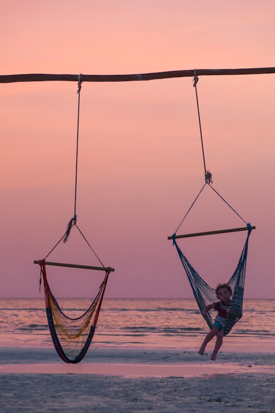 toddler riding swing in Holbox Mexico