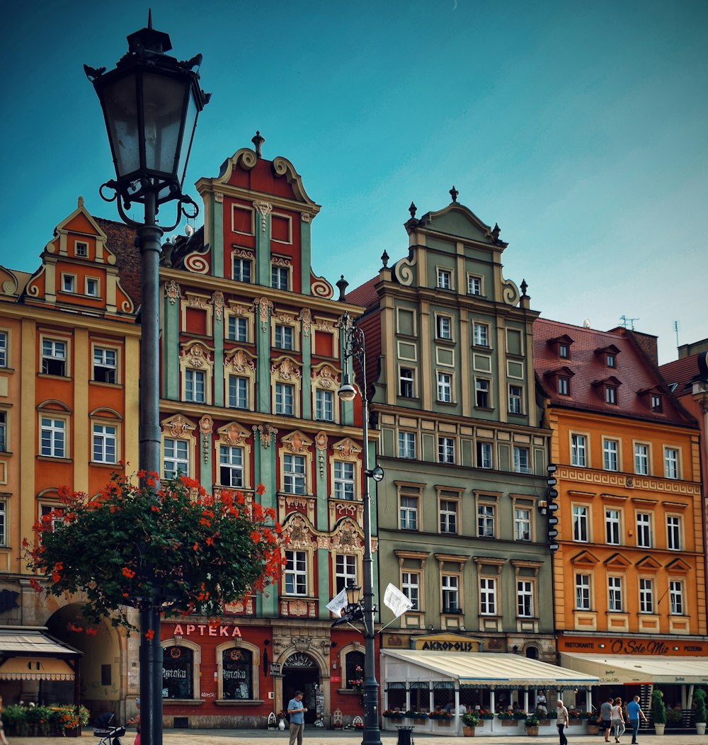 people walking in front of multicolored buildings