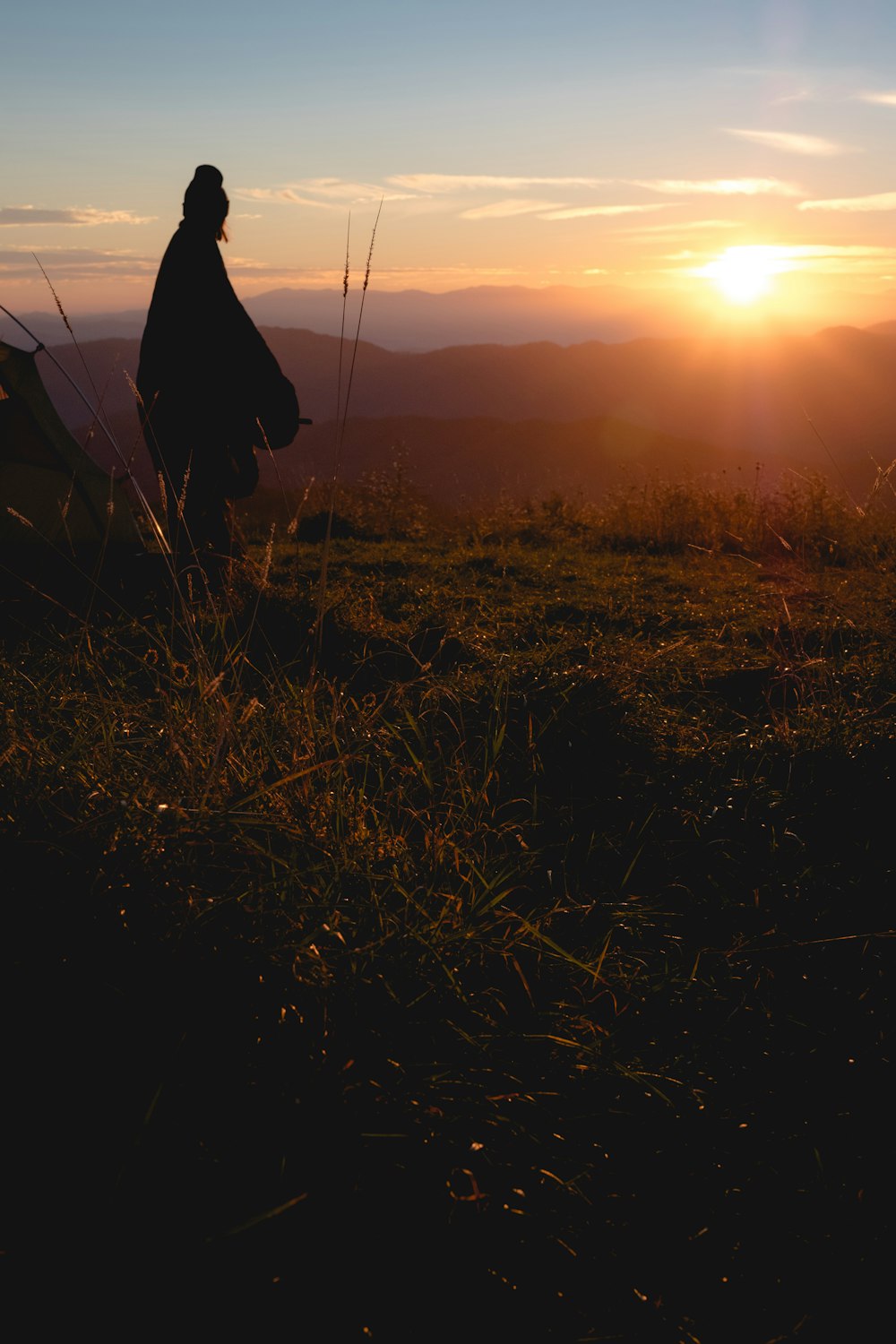 언덕에 서 있는 가운을 입은 사람의 실루엣 사진