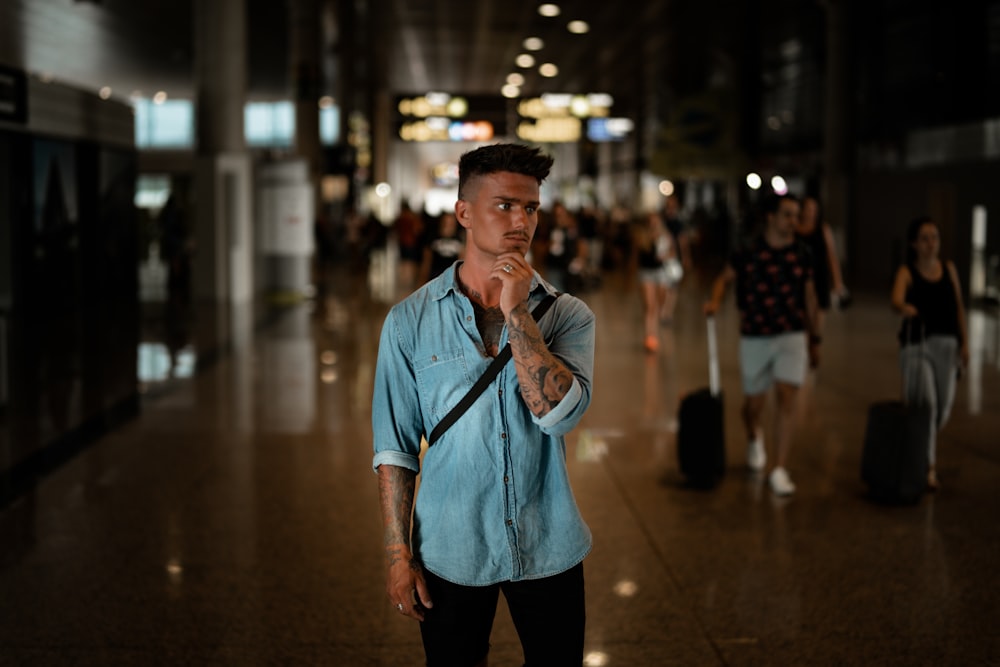 man standing on the floor and touching his chin