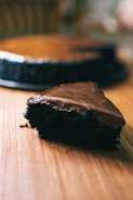 Close-up of a freshly baked chocolate cake with a glossy glaze on a rustic wooden table