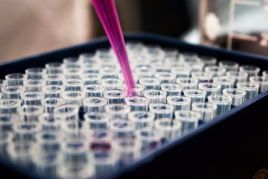 Laboratory scientist working with microscope and medical samples representing pharmaceutical research