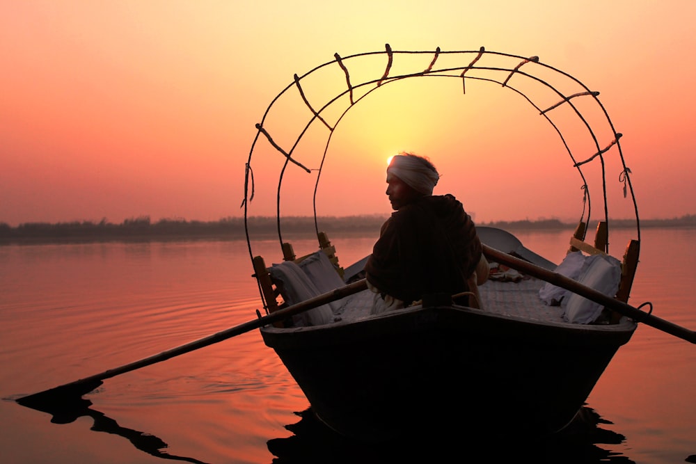 man paddling the boat in body of water