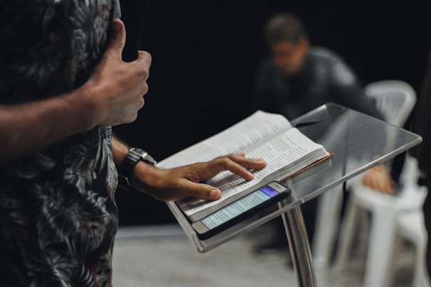 person standing while opening book on stage