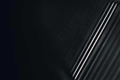 Sleek metal rods arranged artistically on a dark textured background.