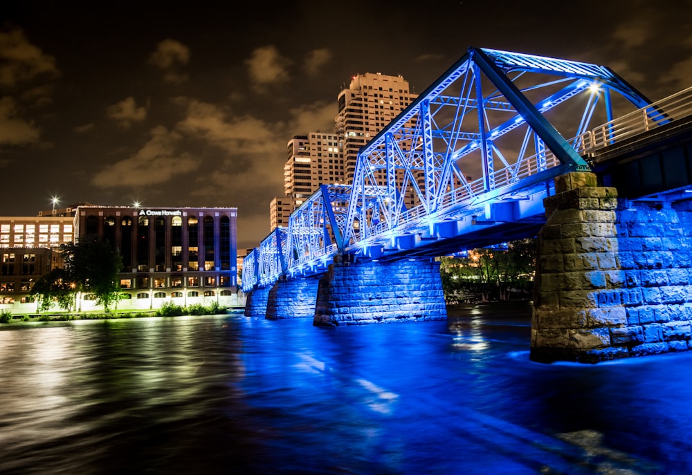 puente sobre el cuerpo de agua que conduce a los edificios durante la noche