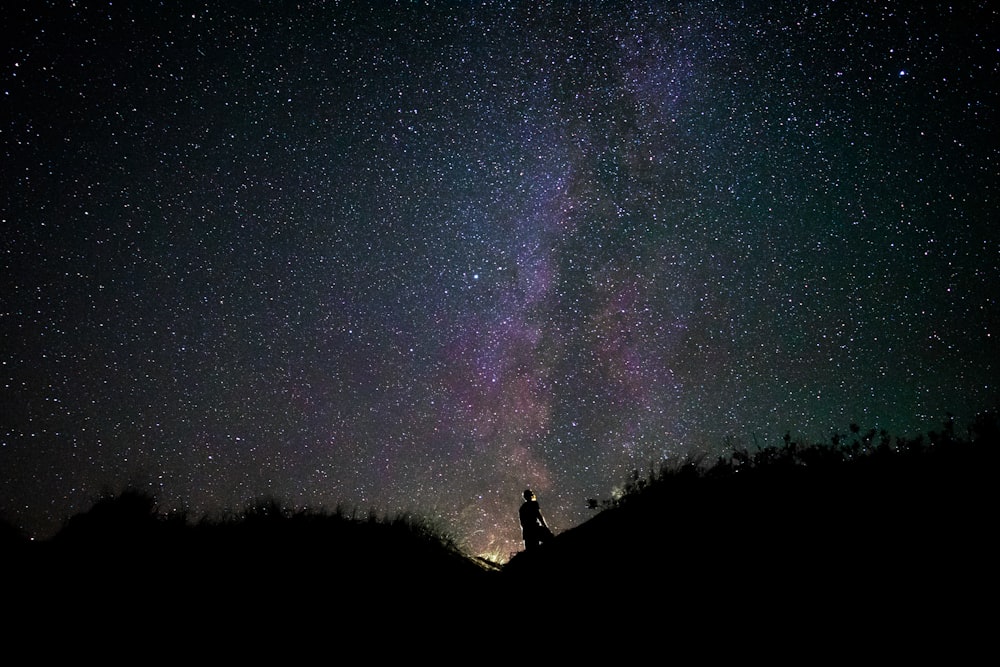 夜の山の上の男のシルエット