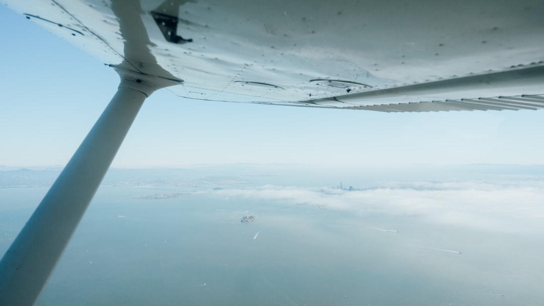 white plane flying over the clouds