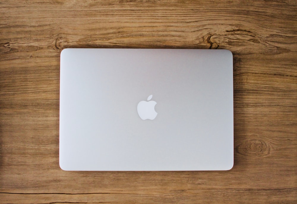 person taking photo of silver MacBook on table