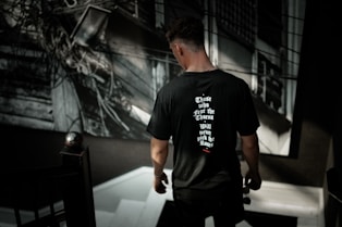 man in black crew-neck T-shirt looking down on white stair