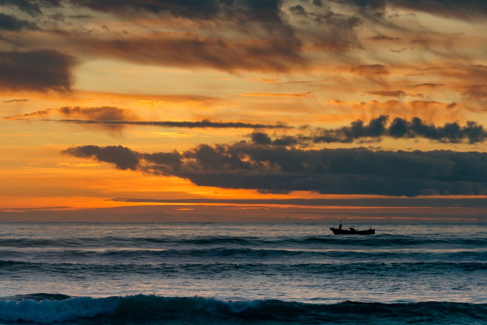 bateau sur le plan d’eau au coucher du soleil
