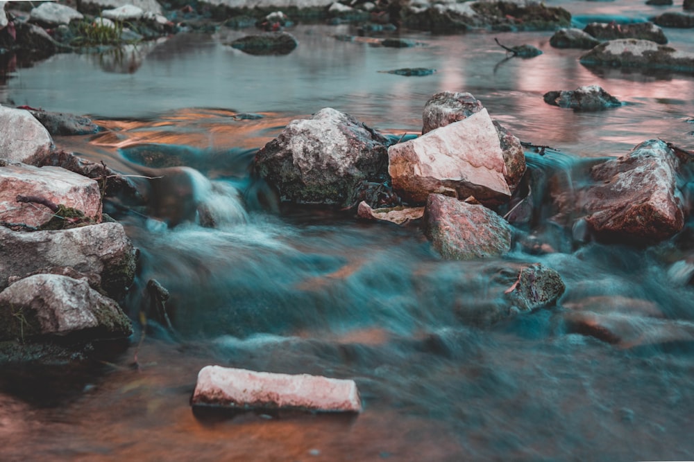 persona que toma una foto de la corriente de agua que fluye