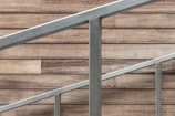 A skilled worker installing a metal railing on a staircase.