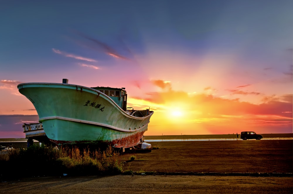 green ship on seashore during golden hour