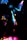 A dynamic and colorful scene featuring a silhouetted figure dancing under vibrant lights. The image captures the movement and energy through streaks of neon pink, blue, and yellow against a dark background.