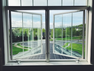 A clean home with sparkling windows reflecting sunlight in a suburban neighborhood.