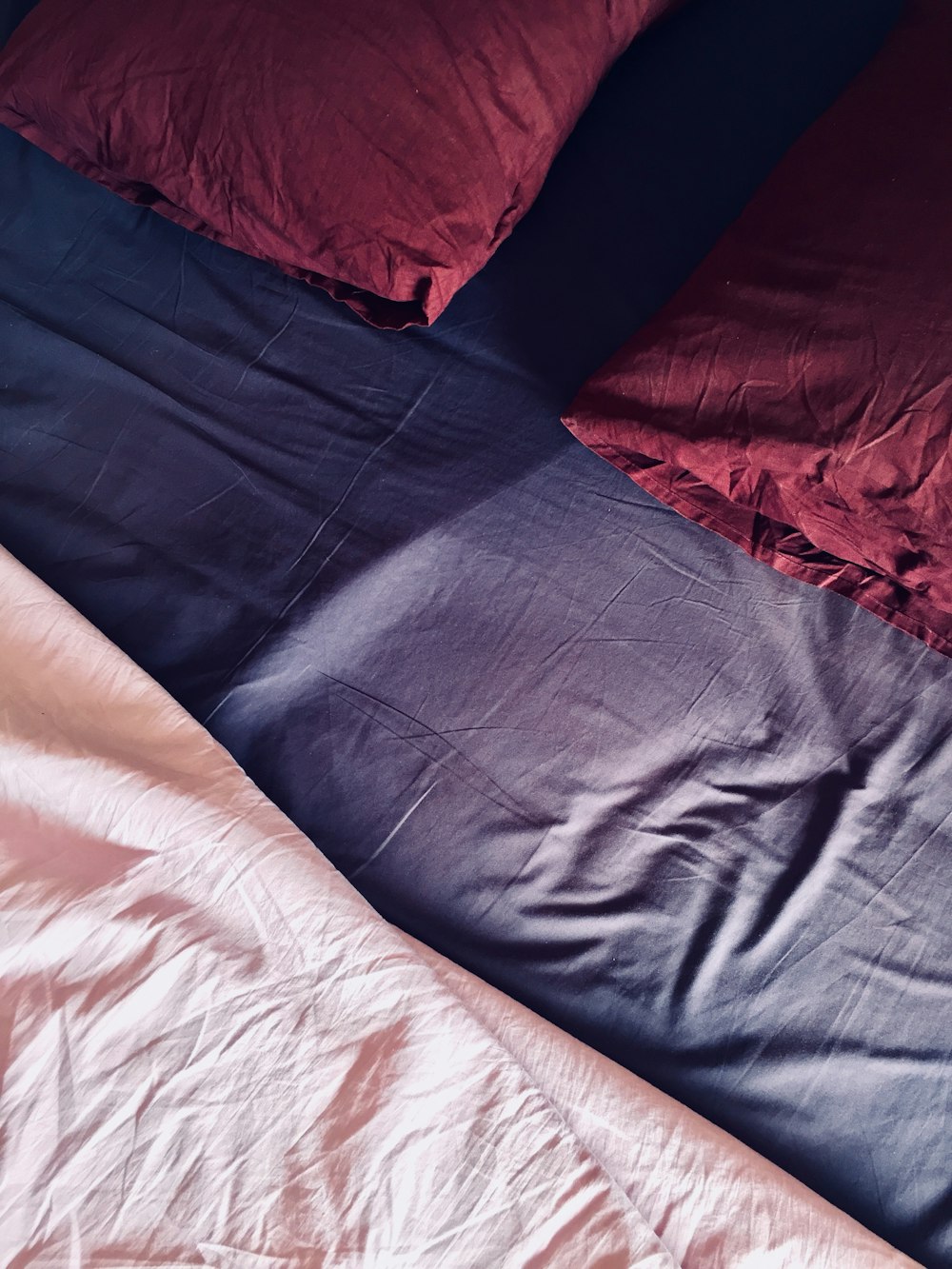 two pillows on blue bed sheet