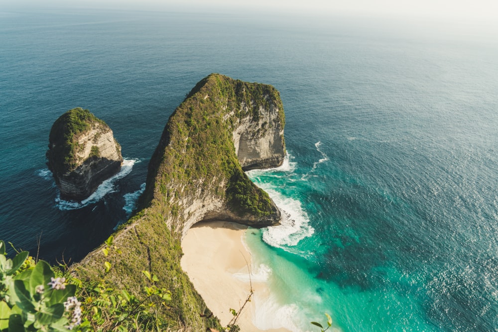 aerial photo of green dense island in teal calm body of water at daytime