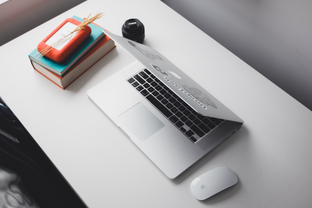 MacBook Air e Apple Magic Mouse no topo da mesa branca