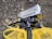 A black Panasonic Full HD camcorder is mounted on a tripod. It has various features labeled on it, including 72x zoom and 10.0 Mega Pixels. The camcorder is positioned above a yellow fabric or bag on a ground covered with dry leaves.