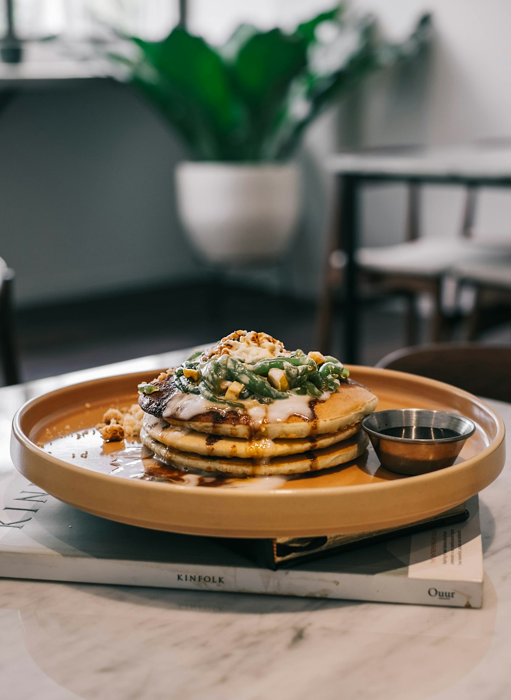 une pile de crêpes posée sur une assiette en bois