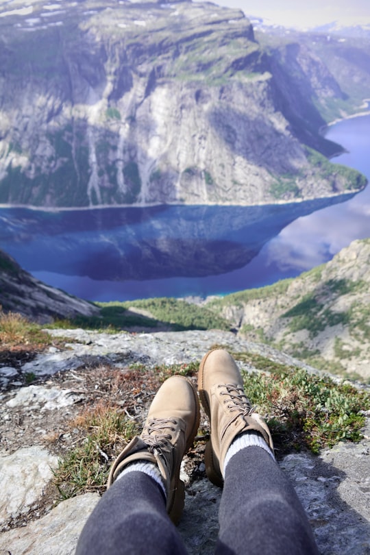 man in brown leather boots on mountain in Trolltunga Norway