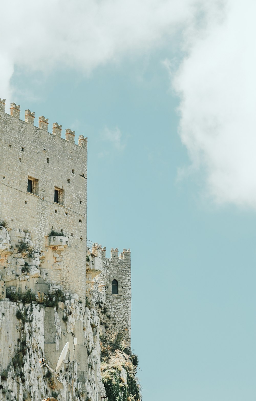 Castelo de concreto cinza sob o céu azul nublado branco