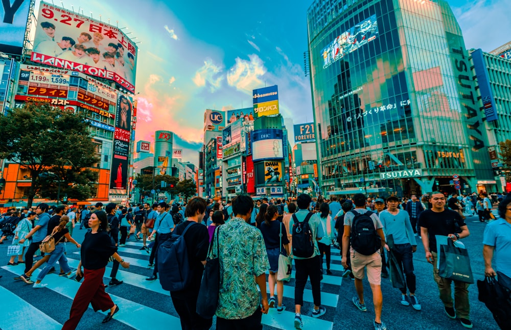 group of people crossing at the pedestrian lane surrounded by buildings