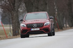 red Mercedes-Benz ML 350 vehicle on roadway near trees