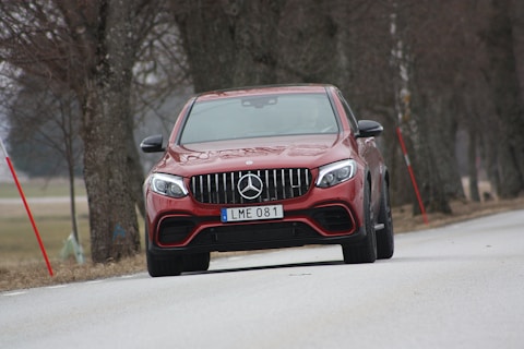 red Mercedes-Benz ML 350 vehicle on roadway near trees