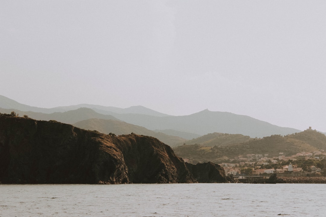 brown mountain beside body of water