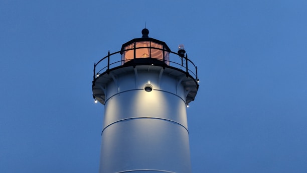 A serene lighthouse glowing warmly at dusk, symbolizing guidance and hope.