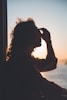man holding forehead under sunset
