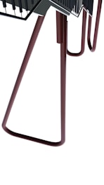 A large metallic structure with elongated legs, somewhat appearing like a chair or table. The design is abstract and industrial with a minimalistic look. The structure is composed of tubular brown legs leading up to a flat, darker surface with railing details.