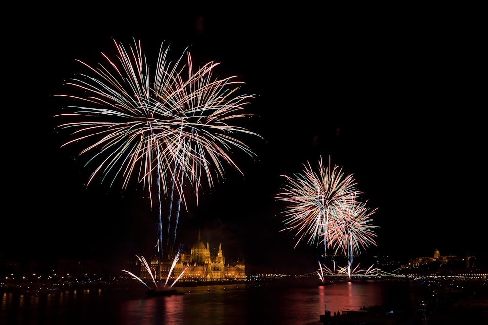 fogos de artifício sobre o templo perto de corpo de água calma