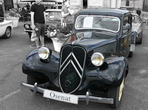 A shiny polished car reflecting light in an outdoor setting.