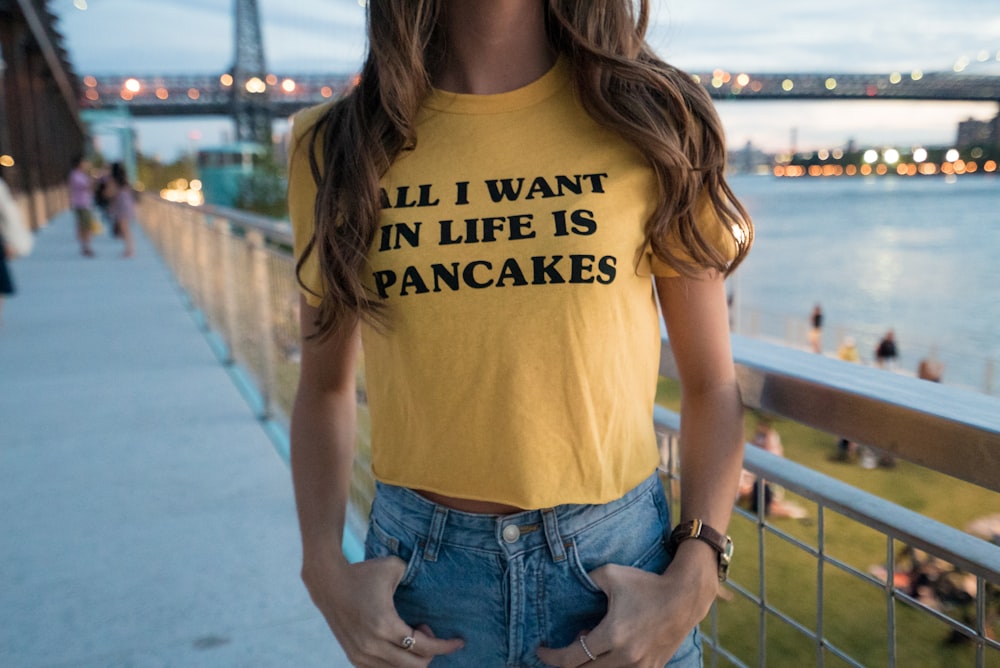 woman in yellow crew-neck t-shirt and blue denim bottoms