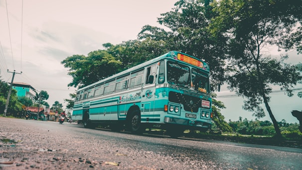 A large luxury coach driving along a highway with a clear blue sky.